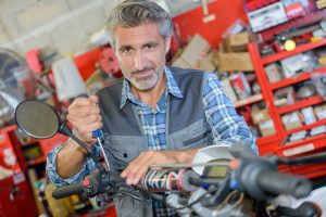 man repairing motorbike in a storag unit