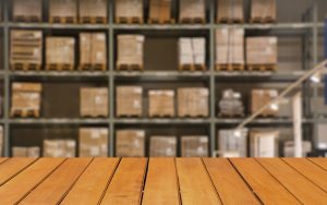 Abstract blurred boxes on rows of shelves in big modern warehous